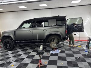 Land Rover Defender on a jack stand as caliper paint is aplied